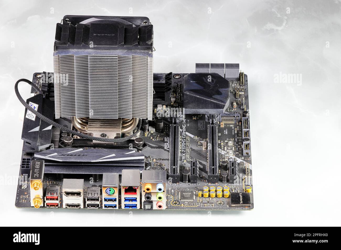 Dissipatore di calore o radiatore del processore del computer sulla scheda madre del computer, radiatore della CPU attiva con ventola, aletta in alluminio e tubo di calore sulla scheda madre del computer. Foto Stock