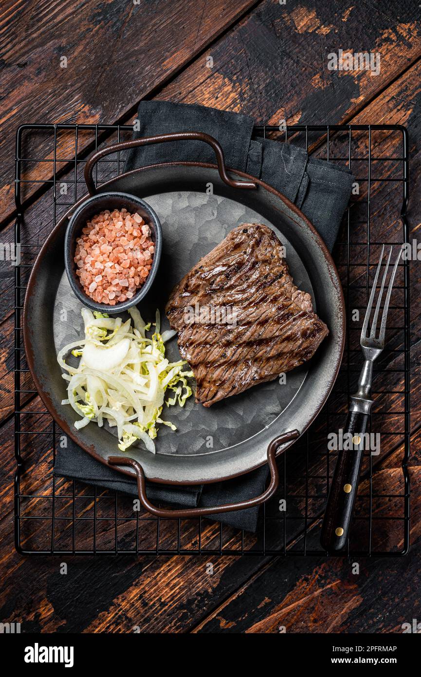 Bistecca di cervo con sale marino e insalata. Sfondo di legno. Vista dall'alto. Foto Stock