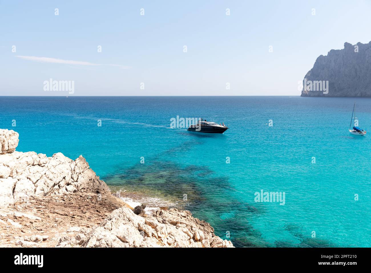 Le aspre scogliere e le acque cristalline di Cala Mesquida a Maiorca, Spagna, offrono uno sfondo mozzafiato per una giornata indimenticabile in spiaggia Foto Stock