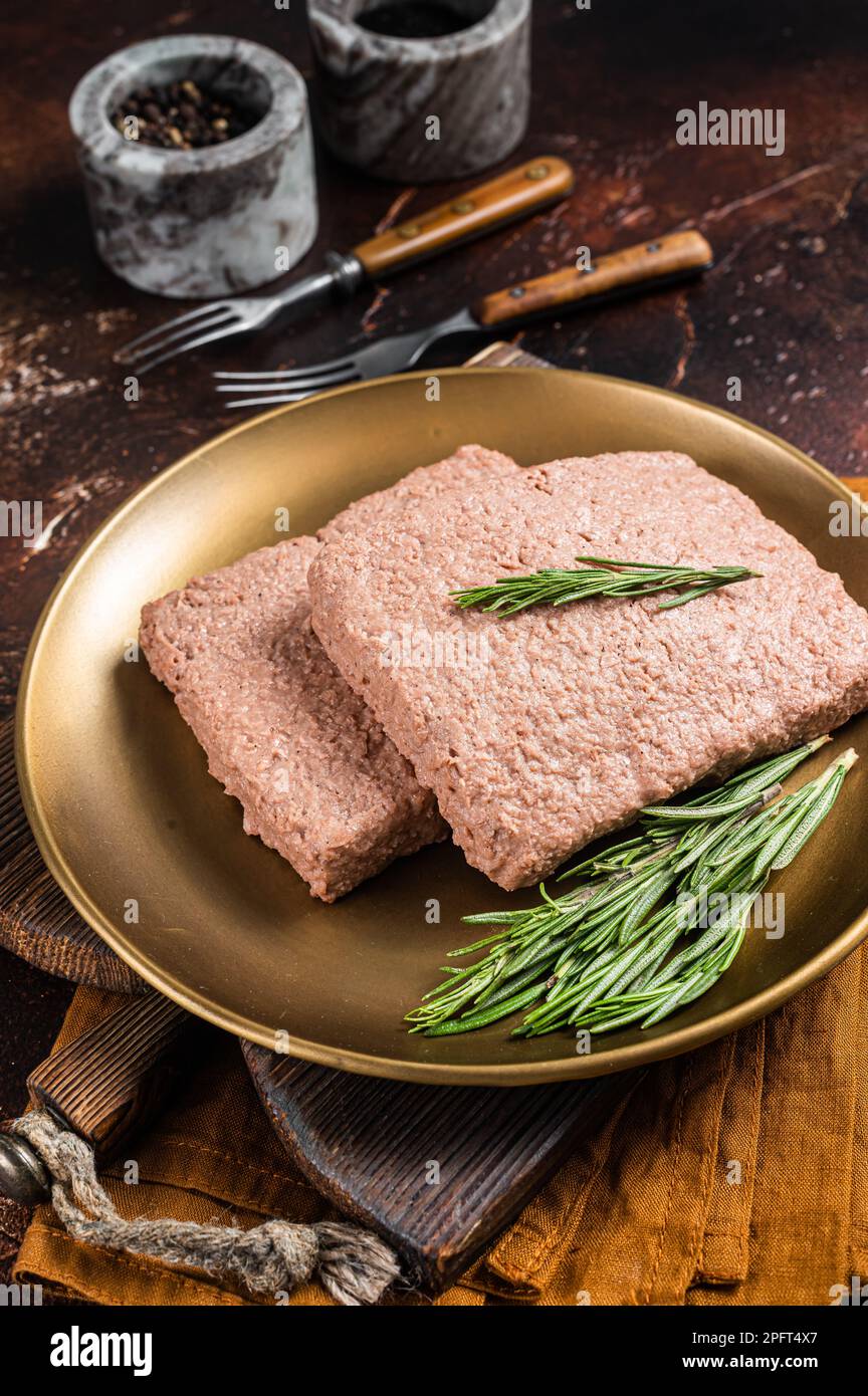 Carne di macina Veggie fresca, carne a base di piante crude con rosmarino. Sfondo scuro. Vista dall'alto. Foto Stock