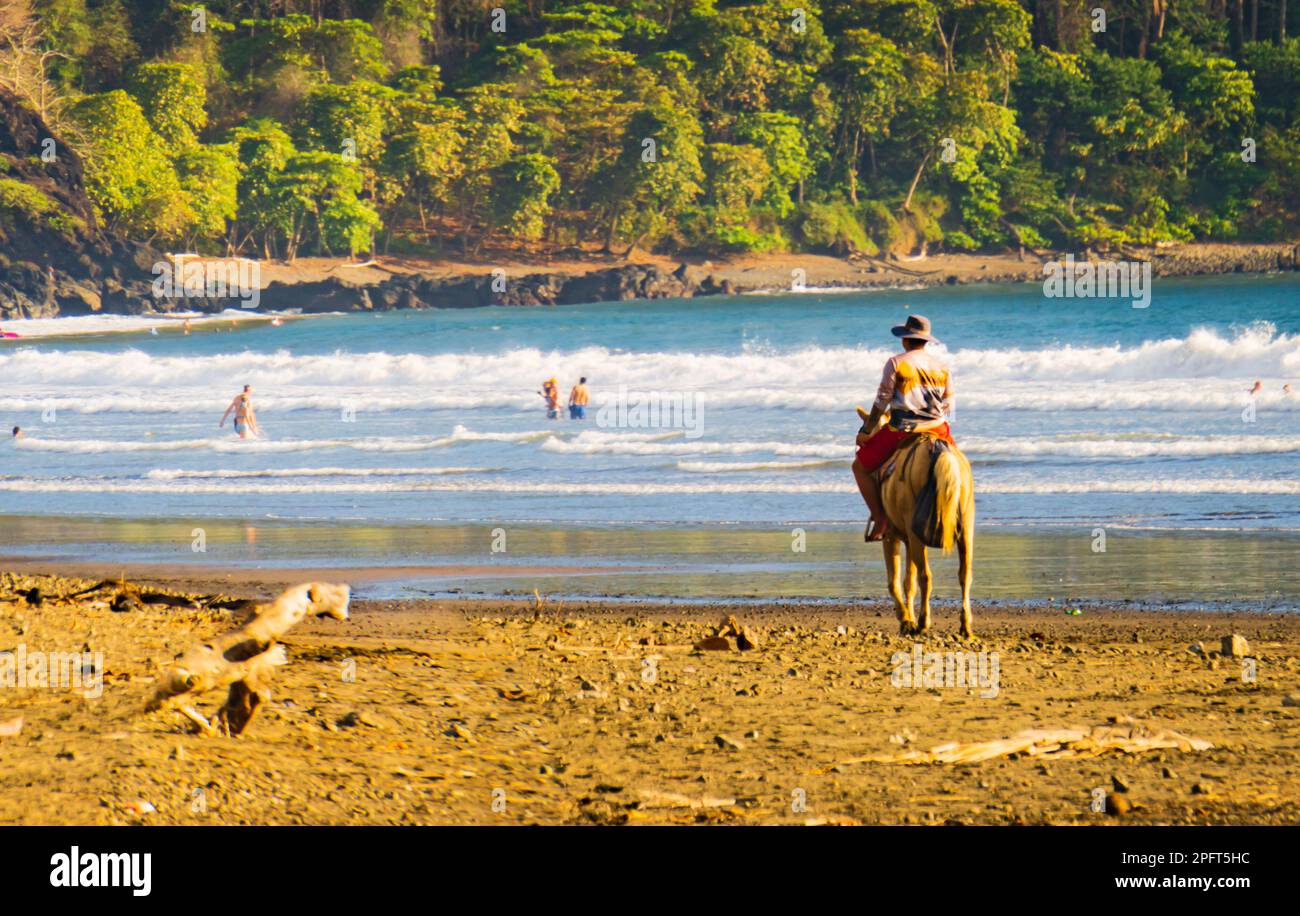 Cowboy costaricano a cavallo sulla spiaggia di Jaco, Costa Rica Foto Stock