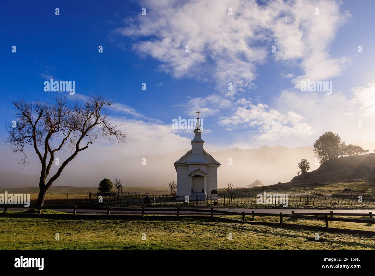 Bassa nebbia dietro la piccola chiesa rurale nella contea di Marin, California all'alba Foto Stock