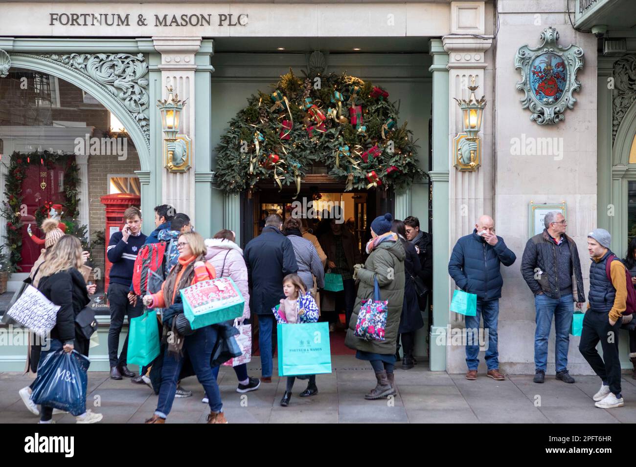 [MccLi0002147] le persone portano le borse blu come lasciano Fortnum & Mason questo pomeriggio, l'ultimo fine settimana di shopping prima di Natale. Immagini Foto Stock