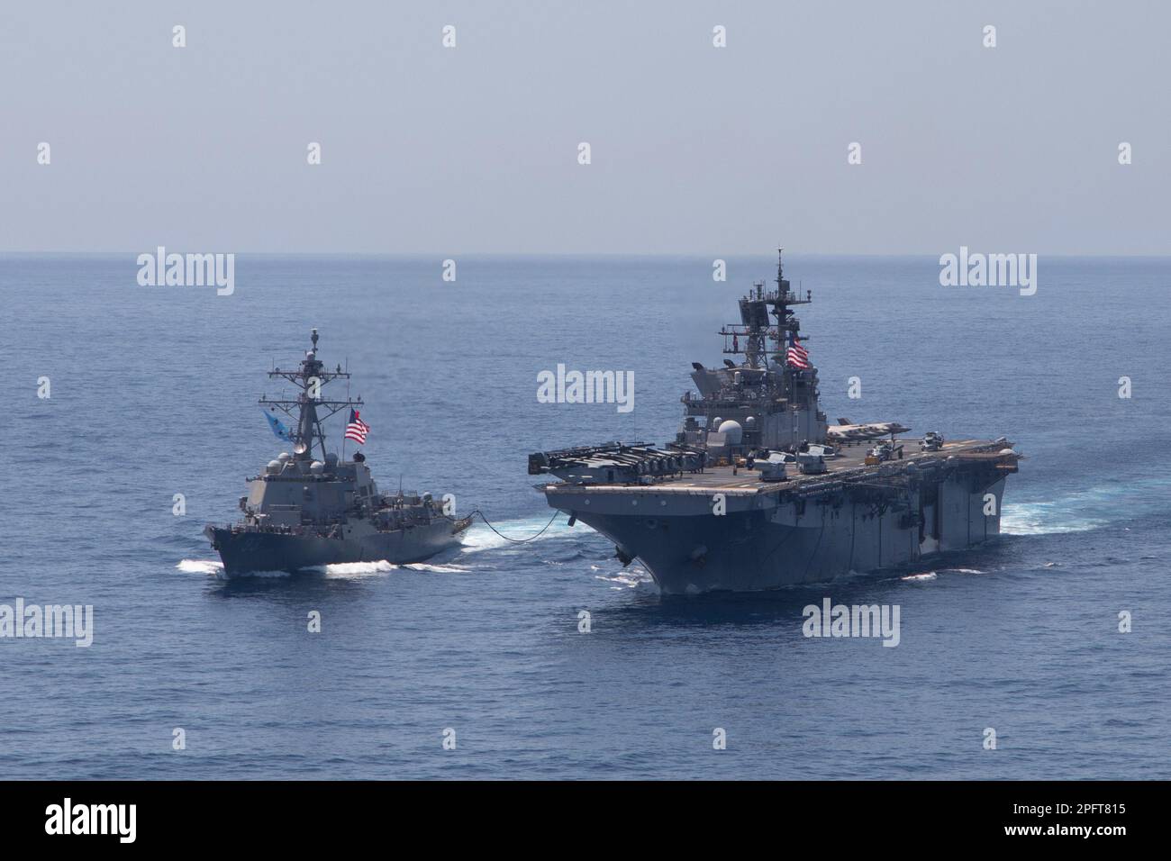 230315-N-ZZ999-1012 SOUTH CHINA SEA (15 marzo 2023) nave d'assalto anfibio USS Makin Island (LHD 8) conduce un esercizio fotografico e il rifornimento in mare con il cacciatorpediniere di classe Arleigh Burke USS Chung Hoon (DDG 93), 15 marzo 2023 nel Mar Cinese Meridionale. La capacità di rifornire le navi in mare dimostra la mobilità e la sostenibilità fornite dalle piattaforme anfibie che conferiscono al team Navy/Marine Corps di Makin Island un vantaggio asimmetrico in un ambiente marittimo. Chung Hoon e Makin Island of Amphibious Squadron (CPR) 7 operano nell'area operativa della flotta 7th, negli Stati Uniti Navy's la Foto Stock
