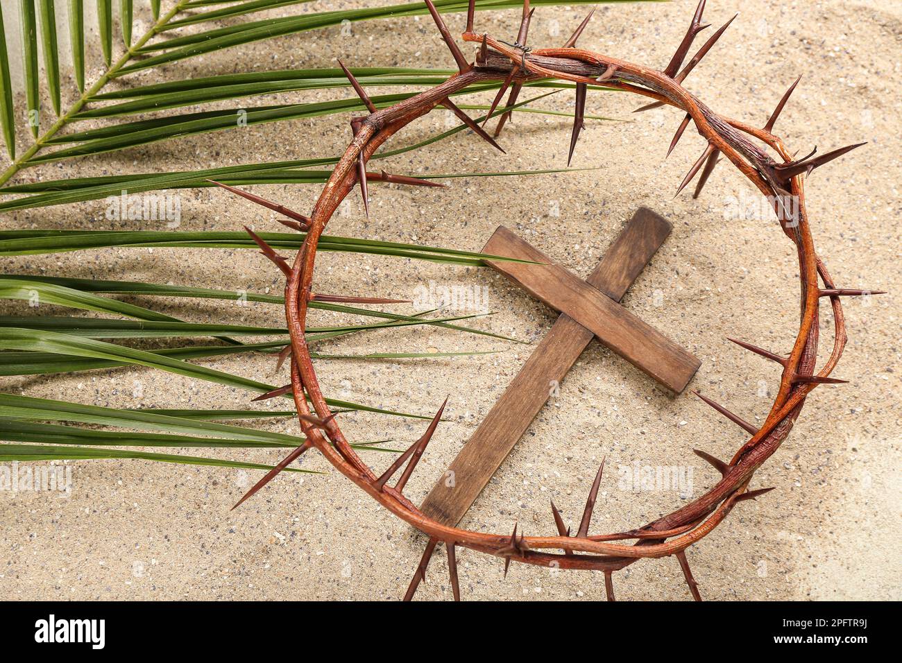 Croce di legno con corona di spine e foglia di palma sulla sabbia. Concetto  di Venerdì Santo Foto stock - Alamy
