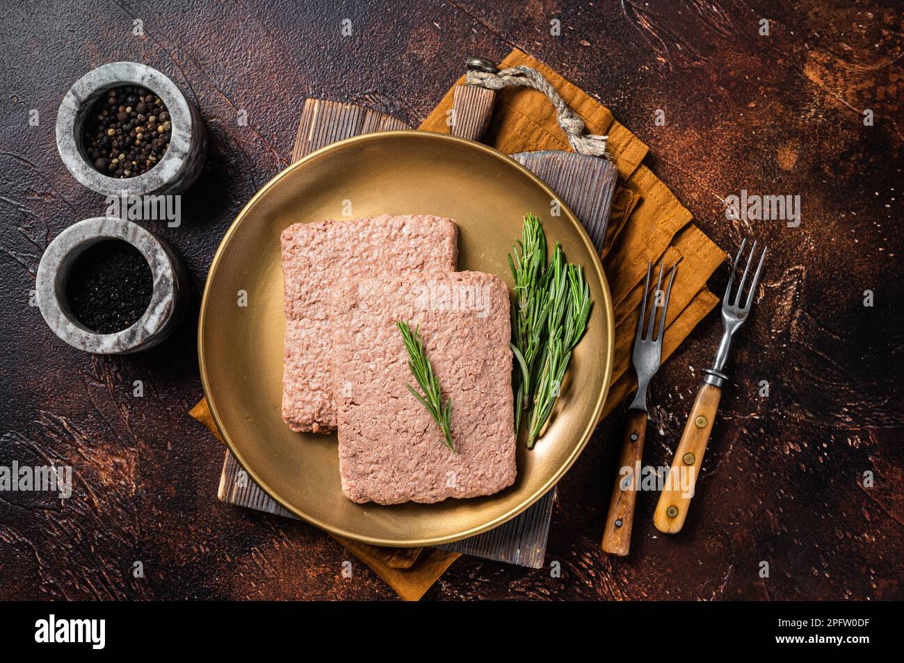 Carne di macina Veggie fresca, carne a base di piante crude con rosmarino. Sfondo scuro. Vista dall'alto. Foto Stock