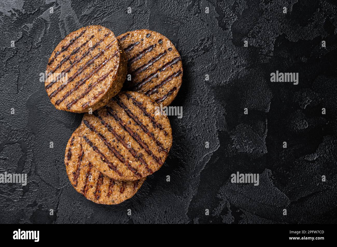 Polpette di carne grigliate, cotolette di carne a base di piante. Sfondo nero. Vista dall'alto. Spazio di copia. Foto Stock