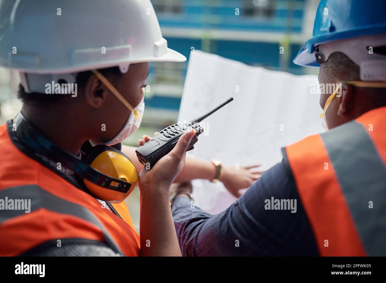 Una migliore collaborazione li avvicina al completamento. un giovane uomo e una donna che si occupa dei progetti di costruzione in un cantiere. Foto Stock