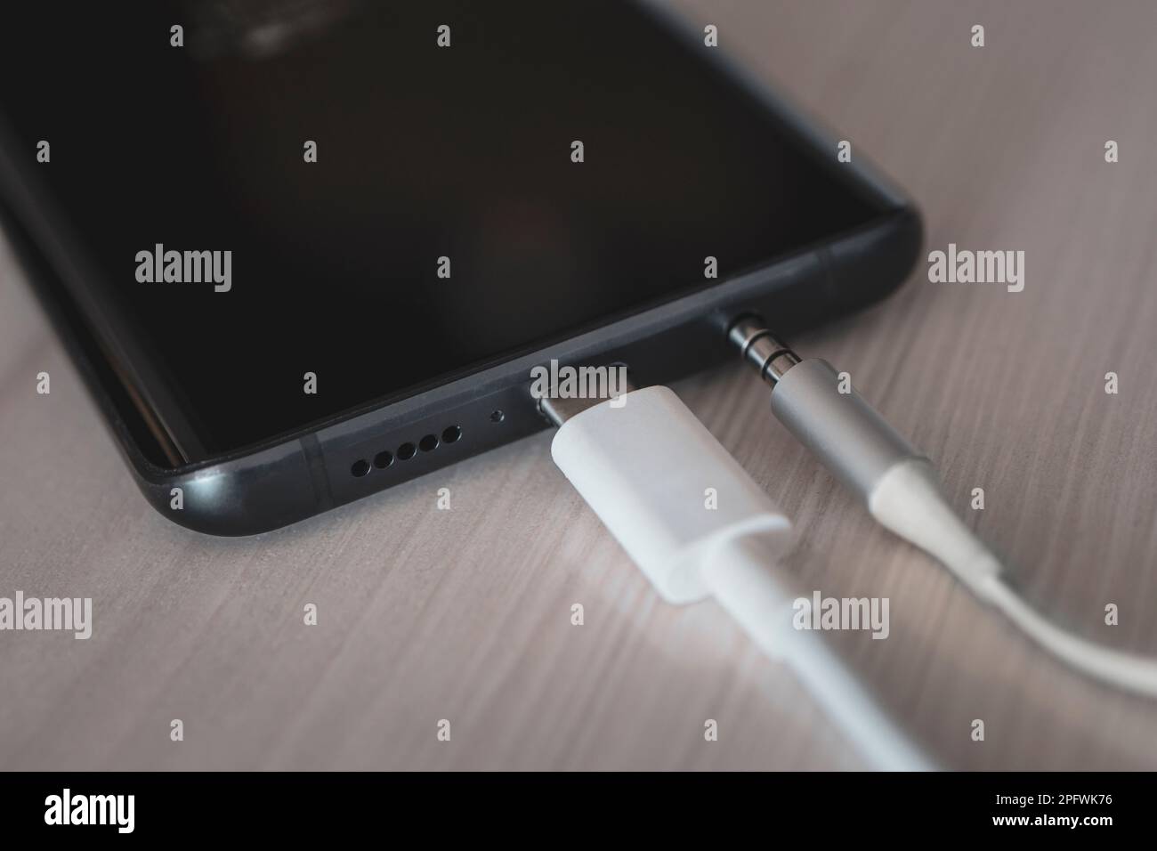 Porta USB Type-C, jack per cuffie da 3,5 mm e schermo sullo smartphone. Macro. Tecnologie moderne. Collegare il jack audio da 3,5 mm a un telefono cellulare nero. Foto Stock