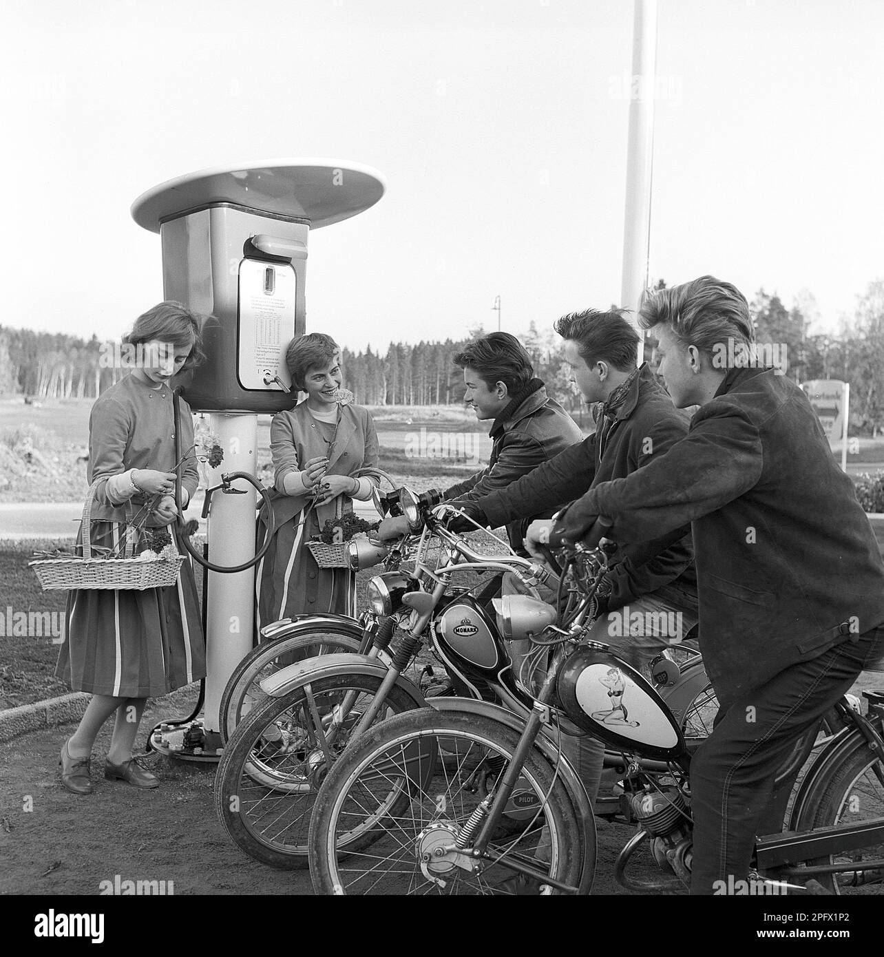 Adolescenti degli anni '1950s. Tre ragazzi adolescenti alla stazione di servizio che viene aperta per la prima volta. I primi clienti sono accolti con fiori. Svezia 13 aprile 1958. Rif. Conard 3864 Foto Stock