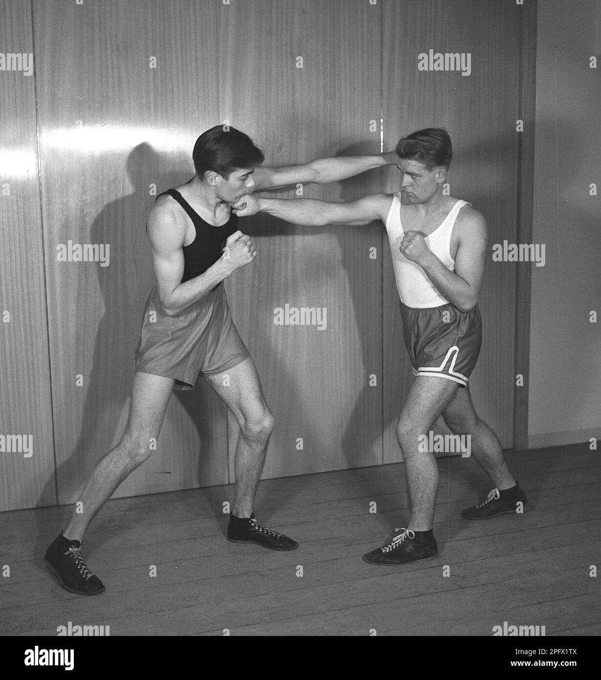 Due giovani boxer che si affrontano, vestiti per la boxe ma privi di guanti di boxe. Entrambi i punzoni terra, una sinistra diritta e una destra diritta grazie a entrambi che non riescono a mantenere la loro guardia in su. Svezia nel 1945. Kristoffersson rif L1-3 Foto Stock