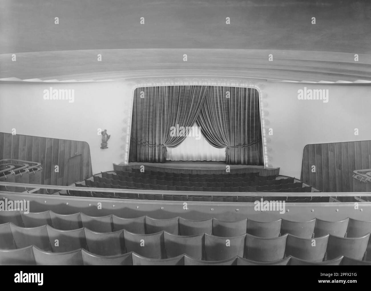 Cinema negli anni '1940s. Un interno di un tipico cinema con posti a sedere vicino allo schermo del film e sul balcone. Lo schermo è parzialmente coperto da tende. Svezia 1940s Foto Stock