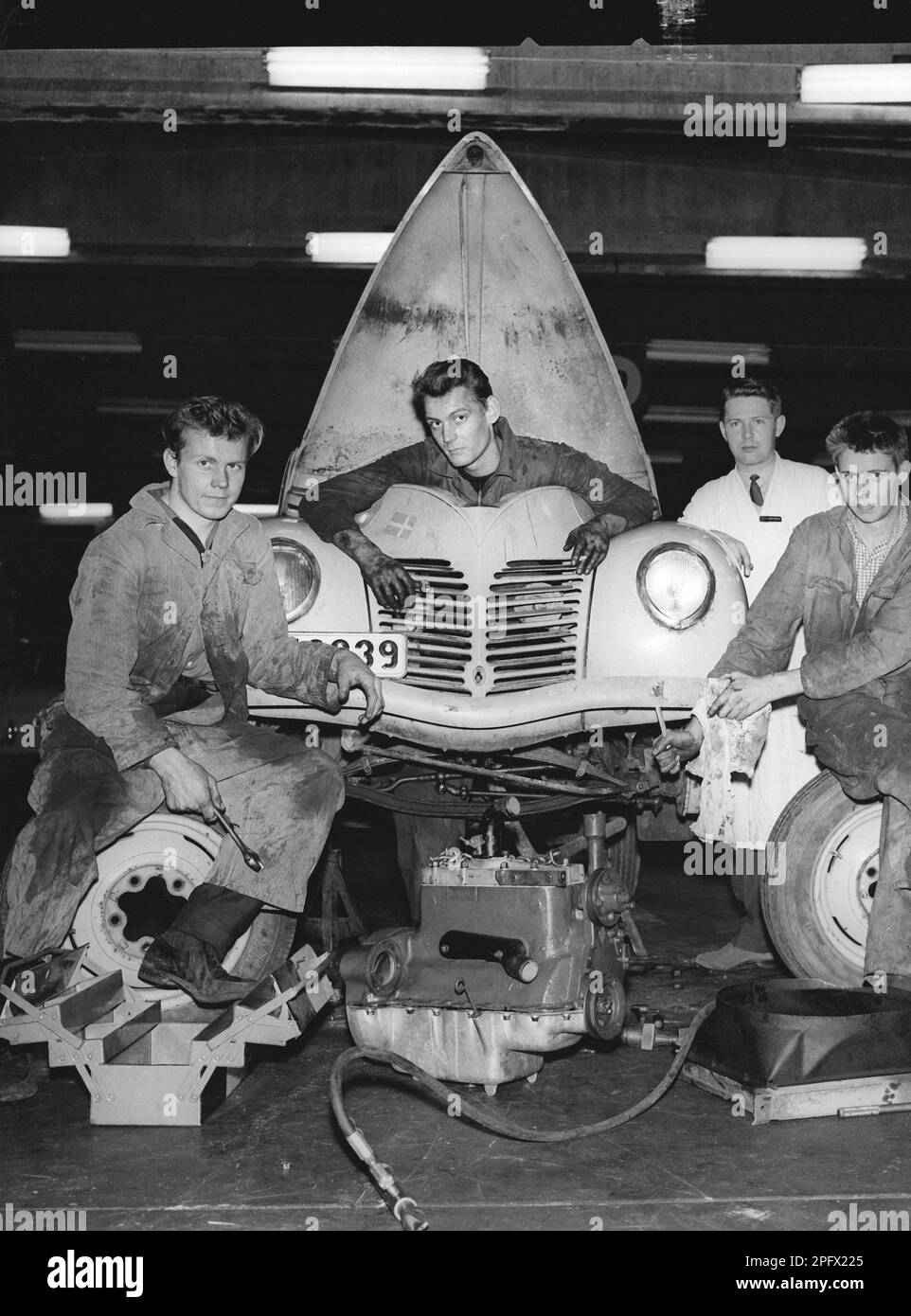 Negli anni '1950s. Un gruppo di giovani che lavorano su un'auto in garage. Il motore viene tuso e uno di essi è in piedi dove si è seduto in auto. Svezia 1959 Foto Stock