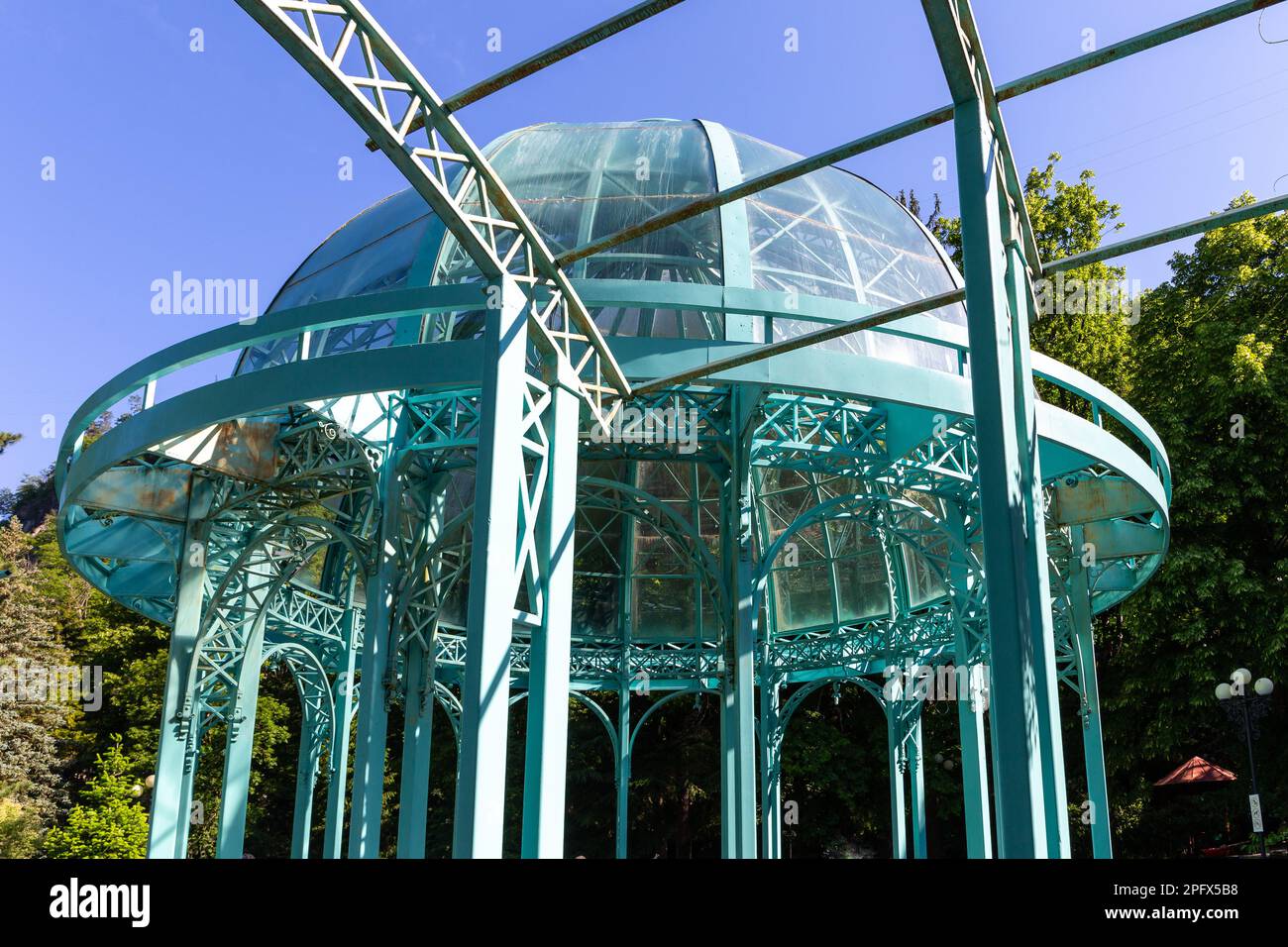 Padiglione in vetro verde con cupola sopra le sorgenti termali di acqua minerale nel Parco Centrale di Borjomi, località termale in Georgia, montagne del Caucaso. Foto Stock
