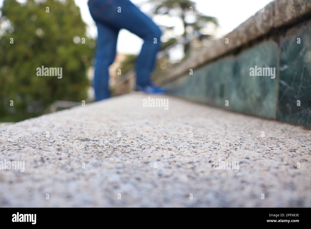 Una persona con jeans blu e scarpe che camminano sulle scale sfocate Foto Stock