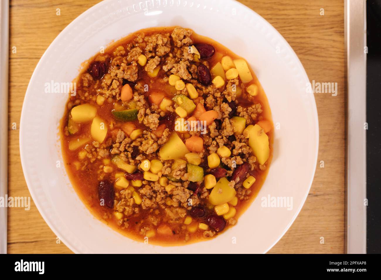 Tradizionale piatto messicano in piatto bianco. Verdure con forcemeat, mais e fagioli rossi. Cibo speziato Foto Stock