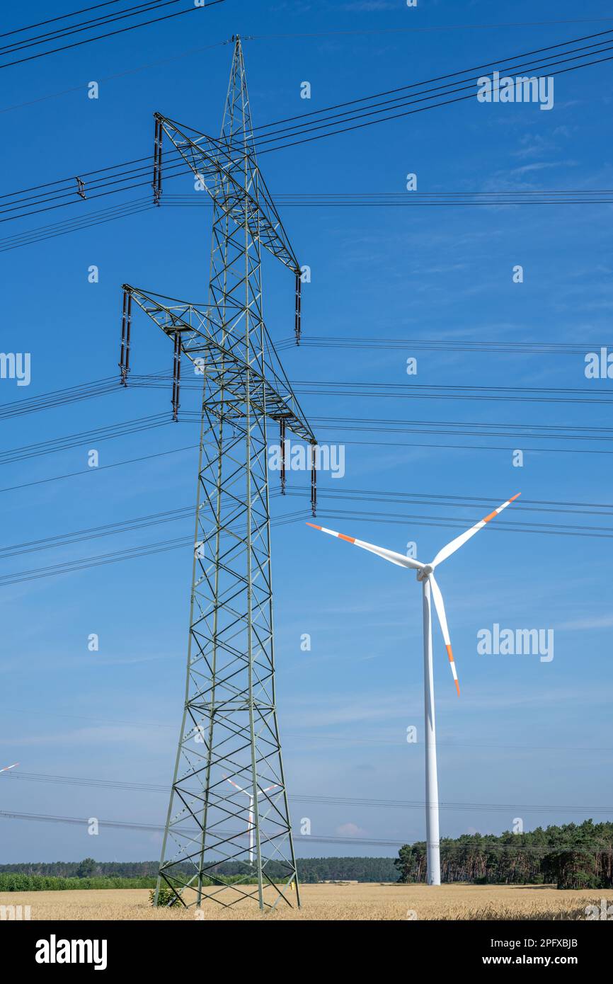 Pilone elettrico, turbina eolica e cavi elettrici visti in Germania Foto Stock