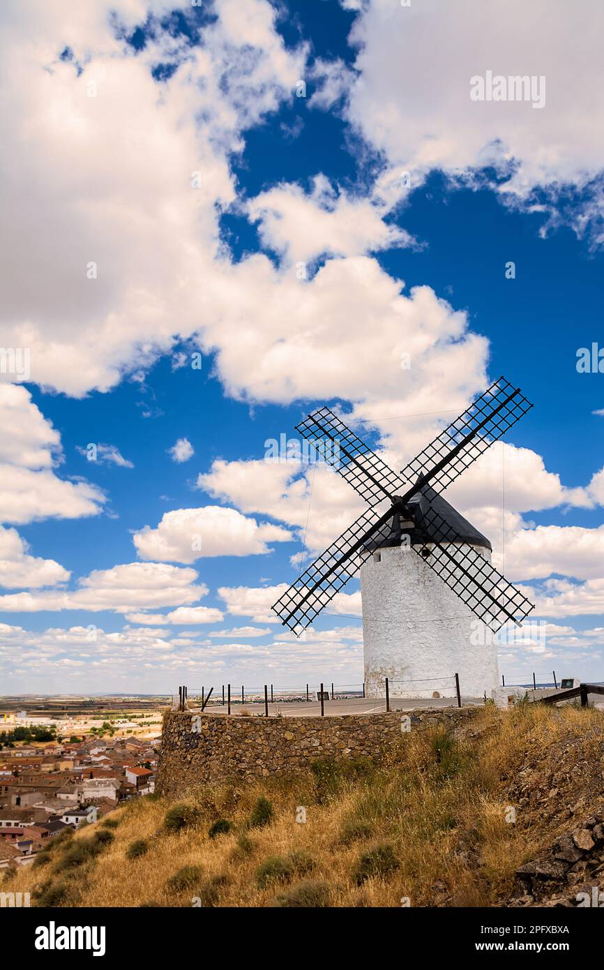 Mulino a vento sulla collina e sullo sfondo il villaggio di Consuegra, Spagna Foto Stock