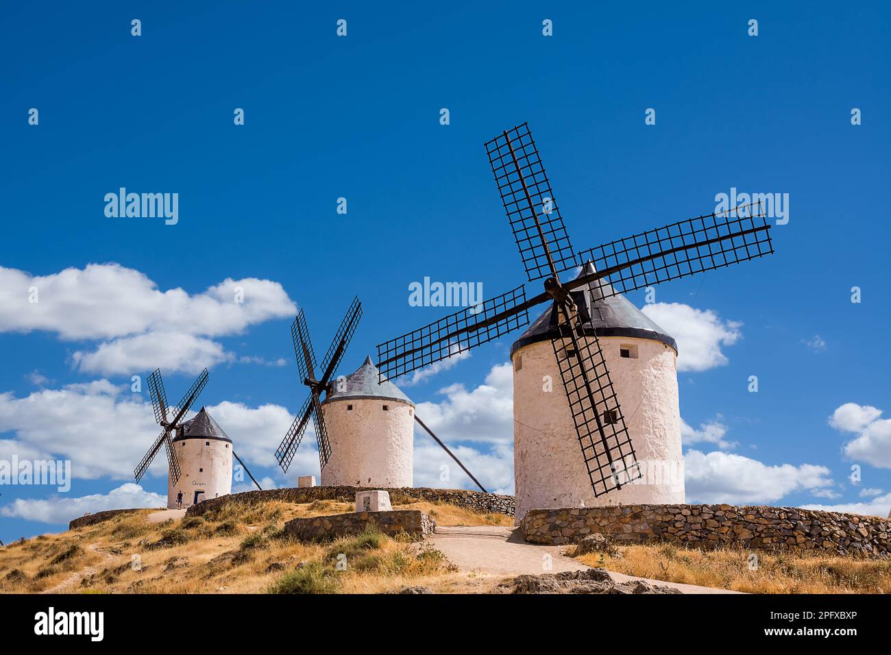 Tre dei mulini a vento di Consuegra sulla collina con cielo blu e nuvole bianche (Spagna) Foto Stock