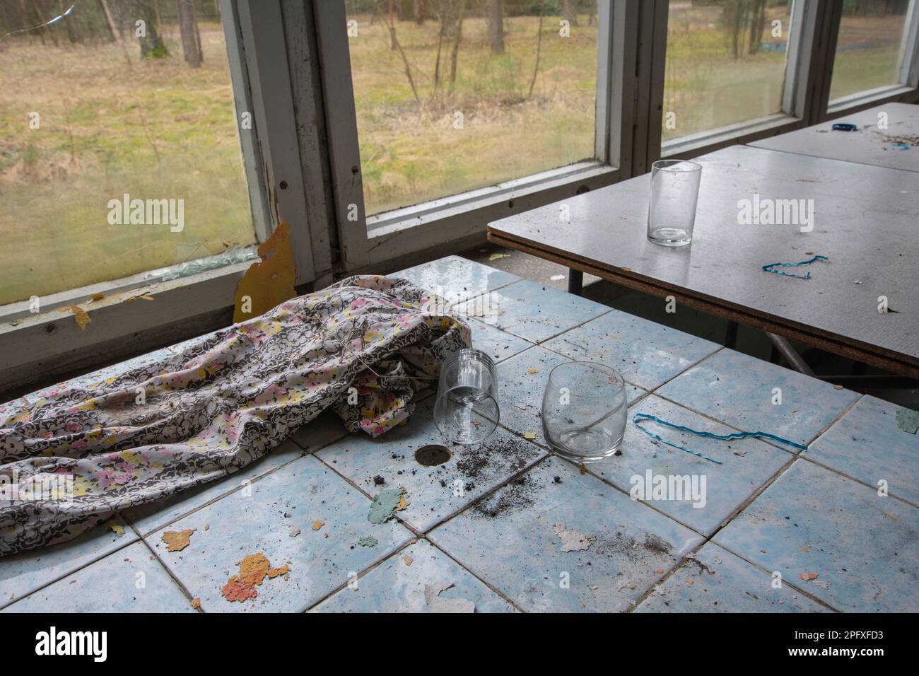 Tavoli vecchi e fatiscenti e tavolini da caffè in un edificio abbandonato. Foto Stock