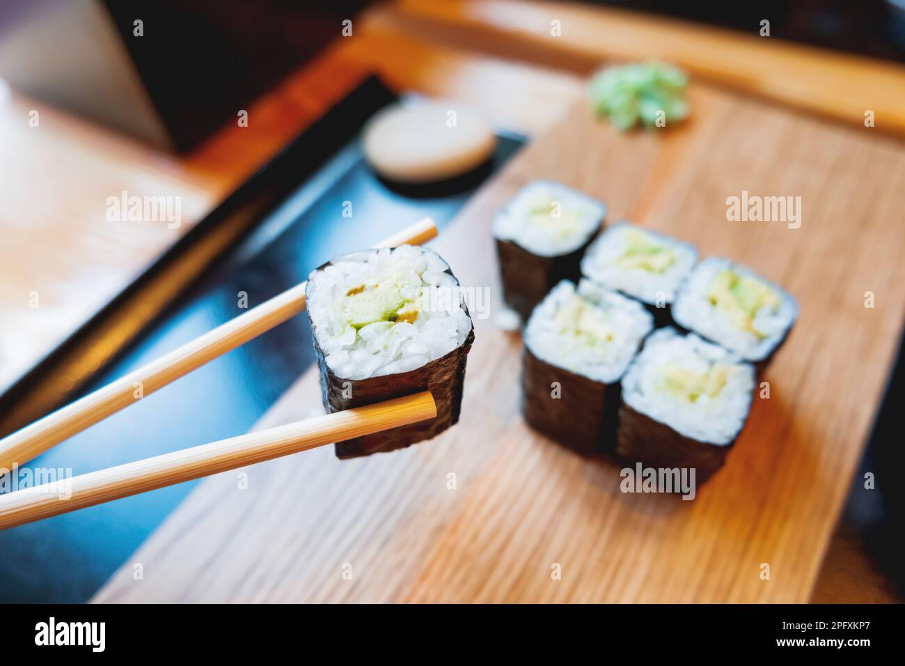 Involtini in nori con avocado, zenzero sottaceto e salsa di soia. Cucina asiatica, piatti tradizionali - sushi. Foto Stock