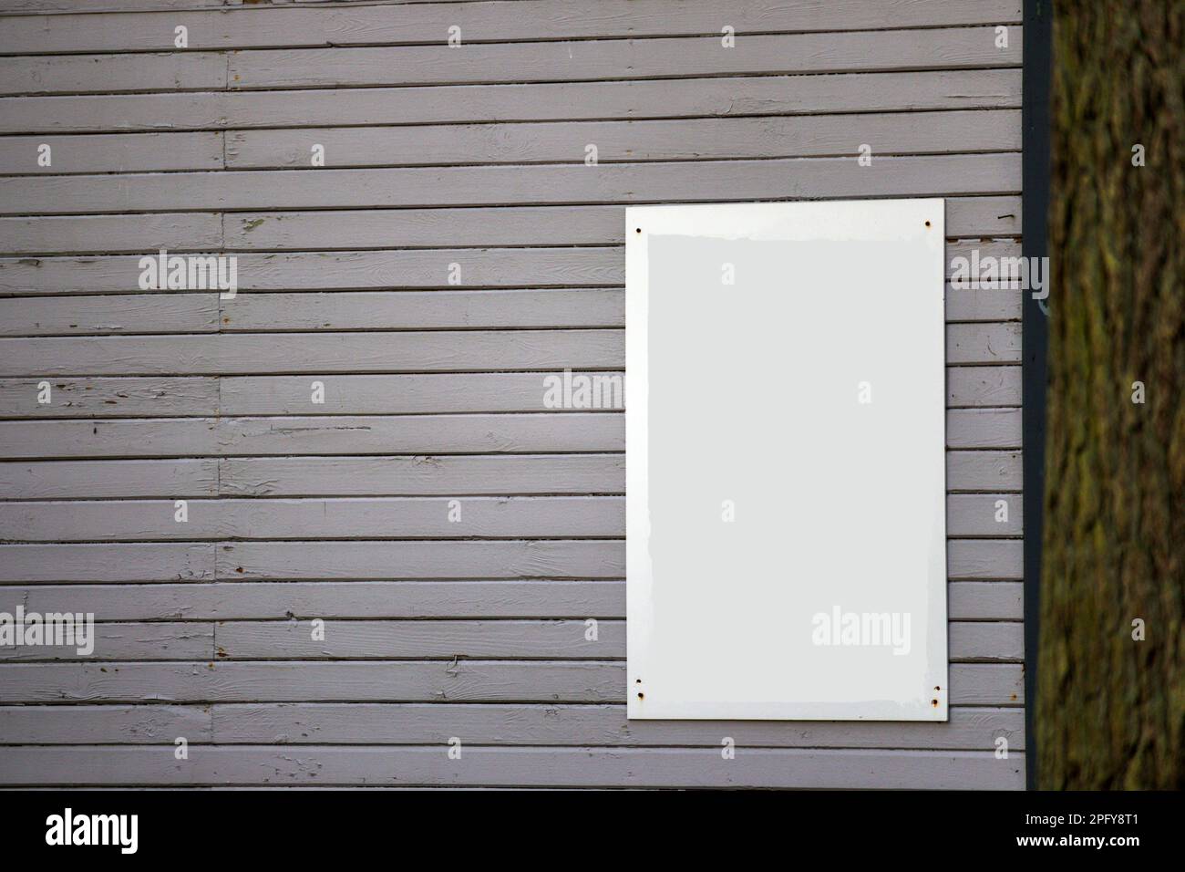 Una parete in legno dipinto di colore grigio-marrone chiaro con una lavagna luminosa Foto Stock