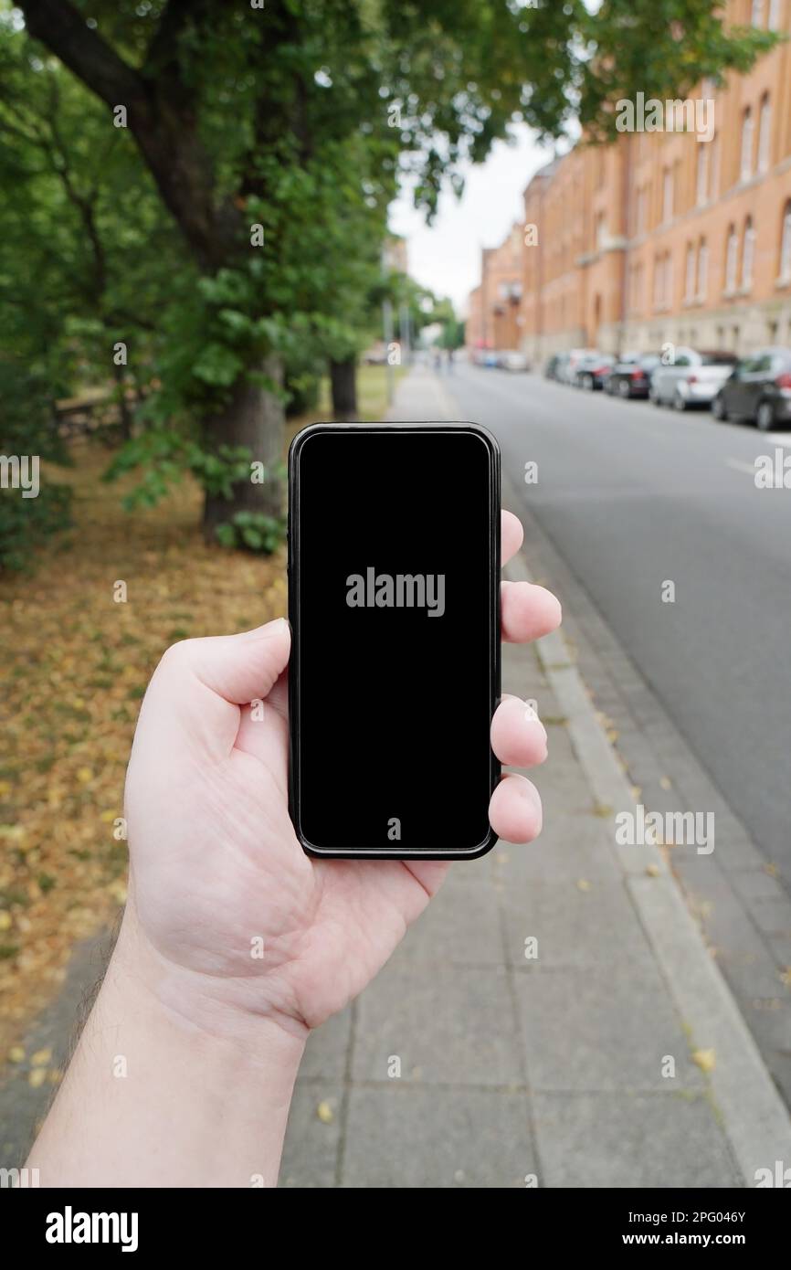 punto di vista di smombie o smartphone zombie. camminando sulla strada con il mobile in mano. schermo vuoto con spazio di copia Foto Stock