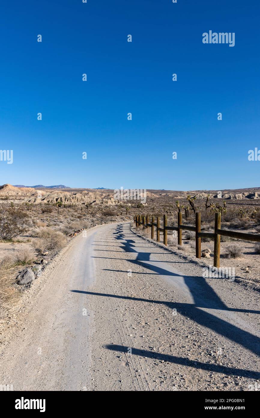 Strada non asfaltata con pali di recinzione nel deserto della california meridionale Foto Stock