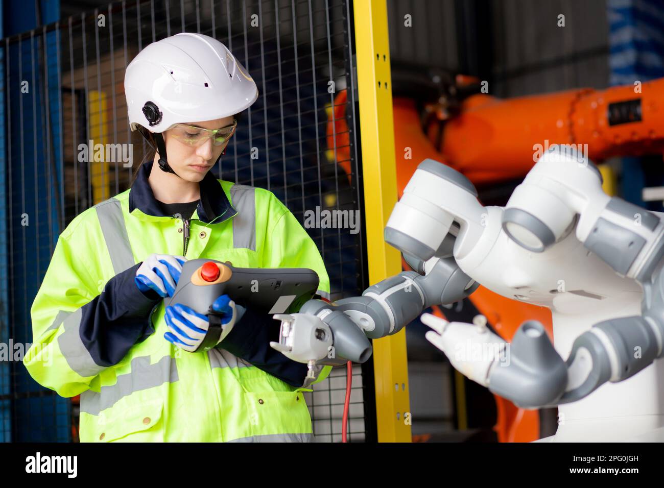 Giovane ingegnere donna controllo e manutenzione macchina robot armi intelligenza tecnologia e innovazione in fabbrica industriale, persone o tecnico ex Foto Stock