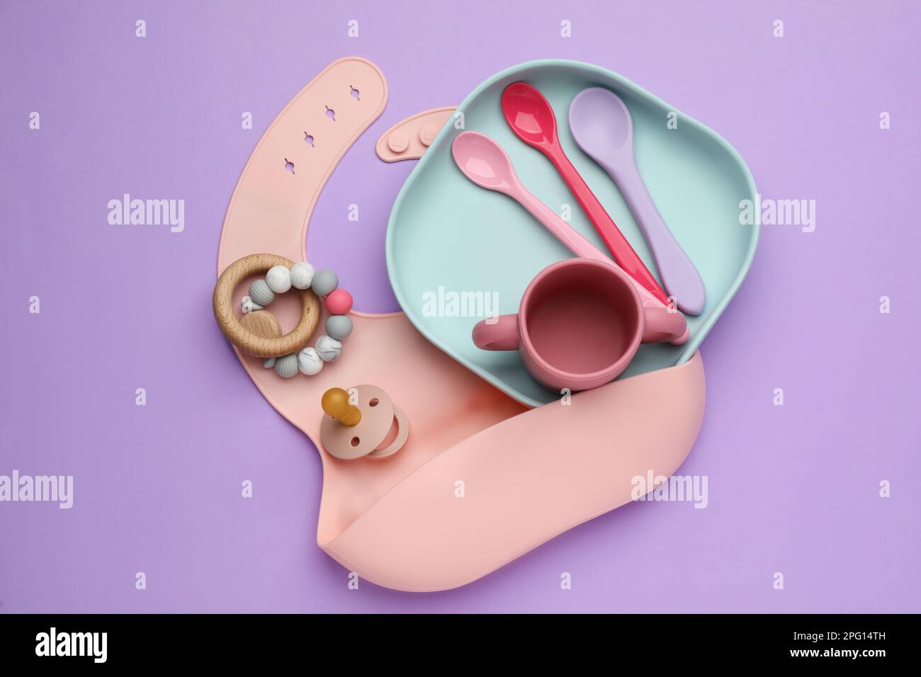 Set di piatti per bambini in silicone, bavaglino, massaggiagengive in legno  su coperta beige con decorazioni natalizie. Spianatura piatta. Telaio  quadrato Foto stock - Alamy