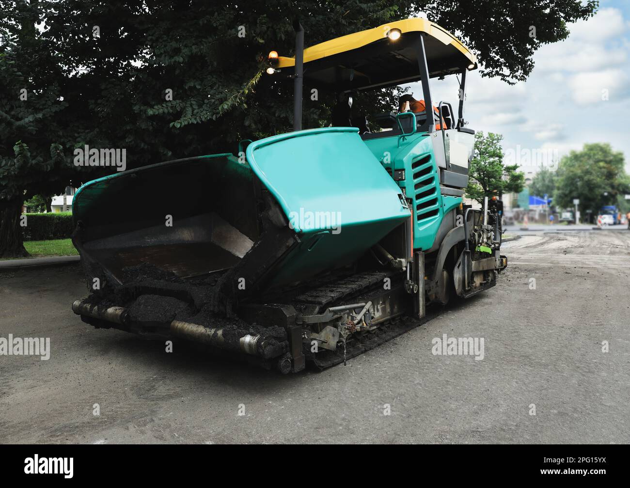 Moderna finitura in asfalto sulla strada cittadina. Servizio di riparazione su strada Foto Stock