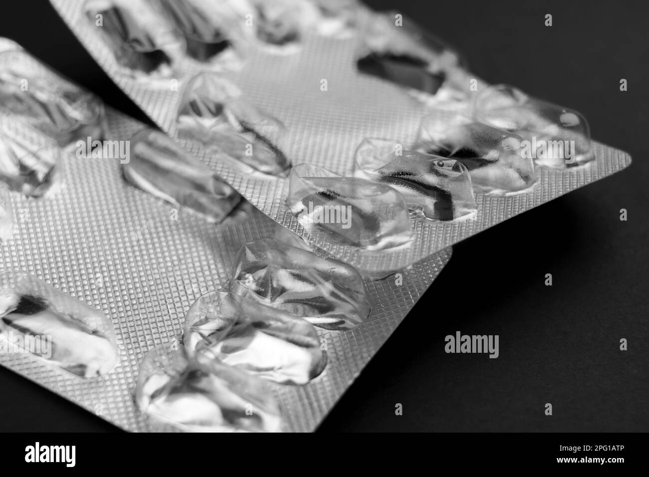 Confezioni vuote di pillole in blister farmaceutico medico usato senza capsule su sfondo nero Foto Stock