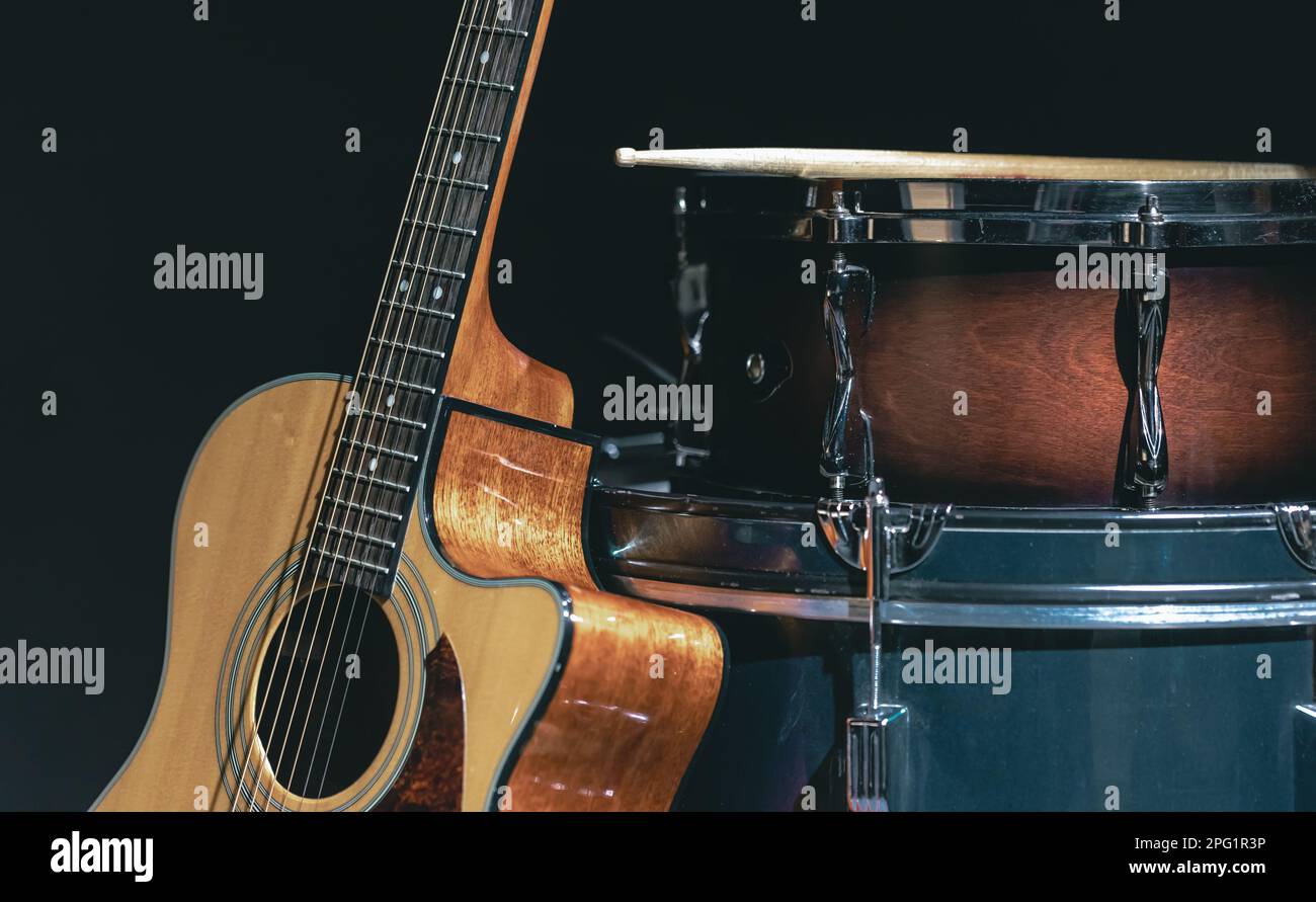 Chitarra acustica e batteria di serpente su uno sfondo nero isolato Foto  stock - Alamy
