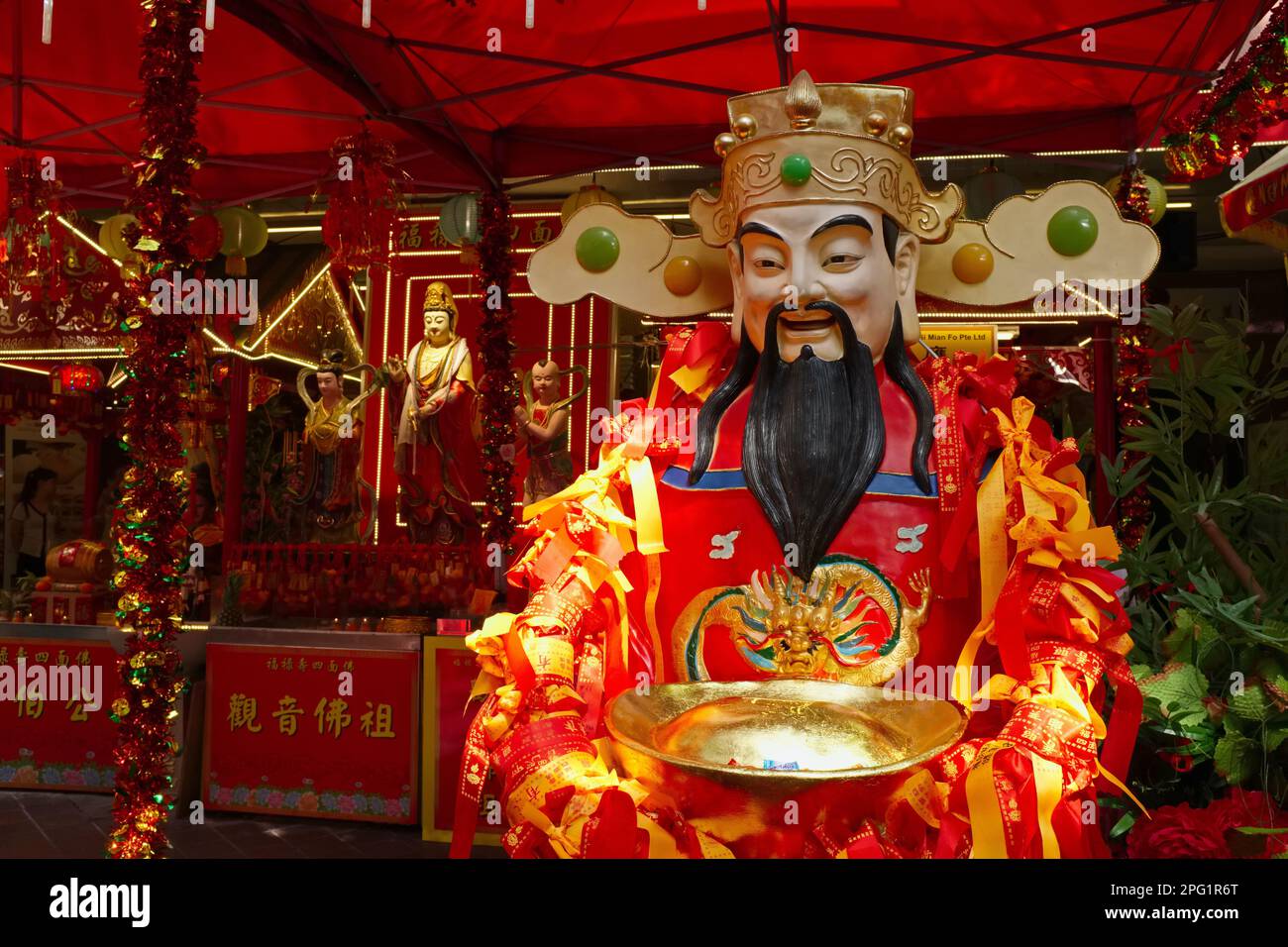 La statua di un dio imperatore taoista fuori da un negozio di paraphernalia religiosa in Waterloo Street, Bugis, Singapore Foto Stock