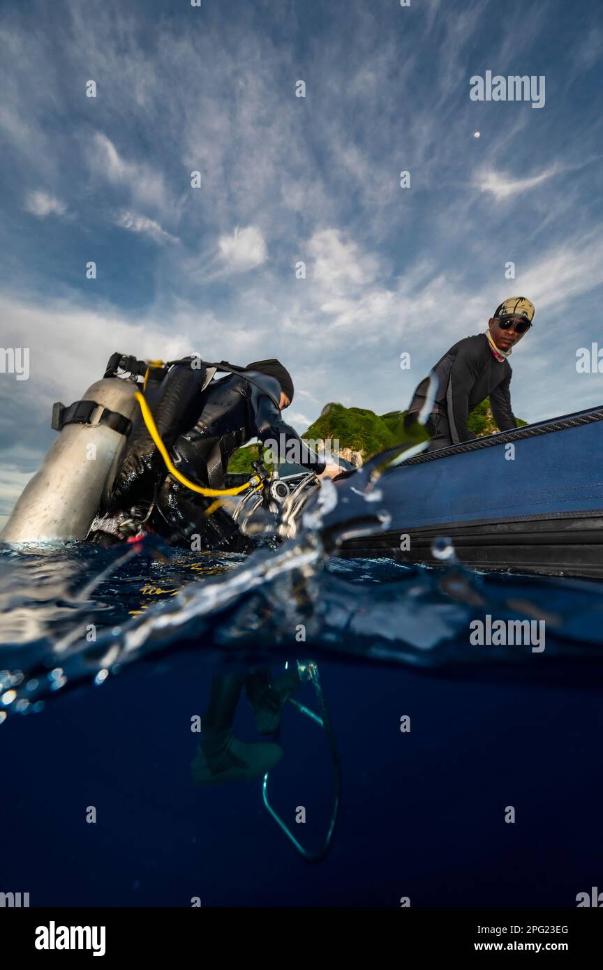 Tuffatore che sale in gommone dopo un'immersione nel mare di banda Foto Stock