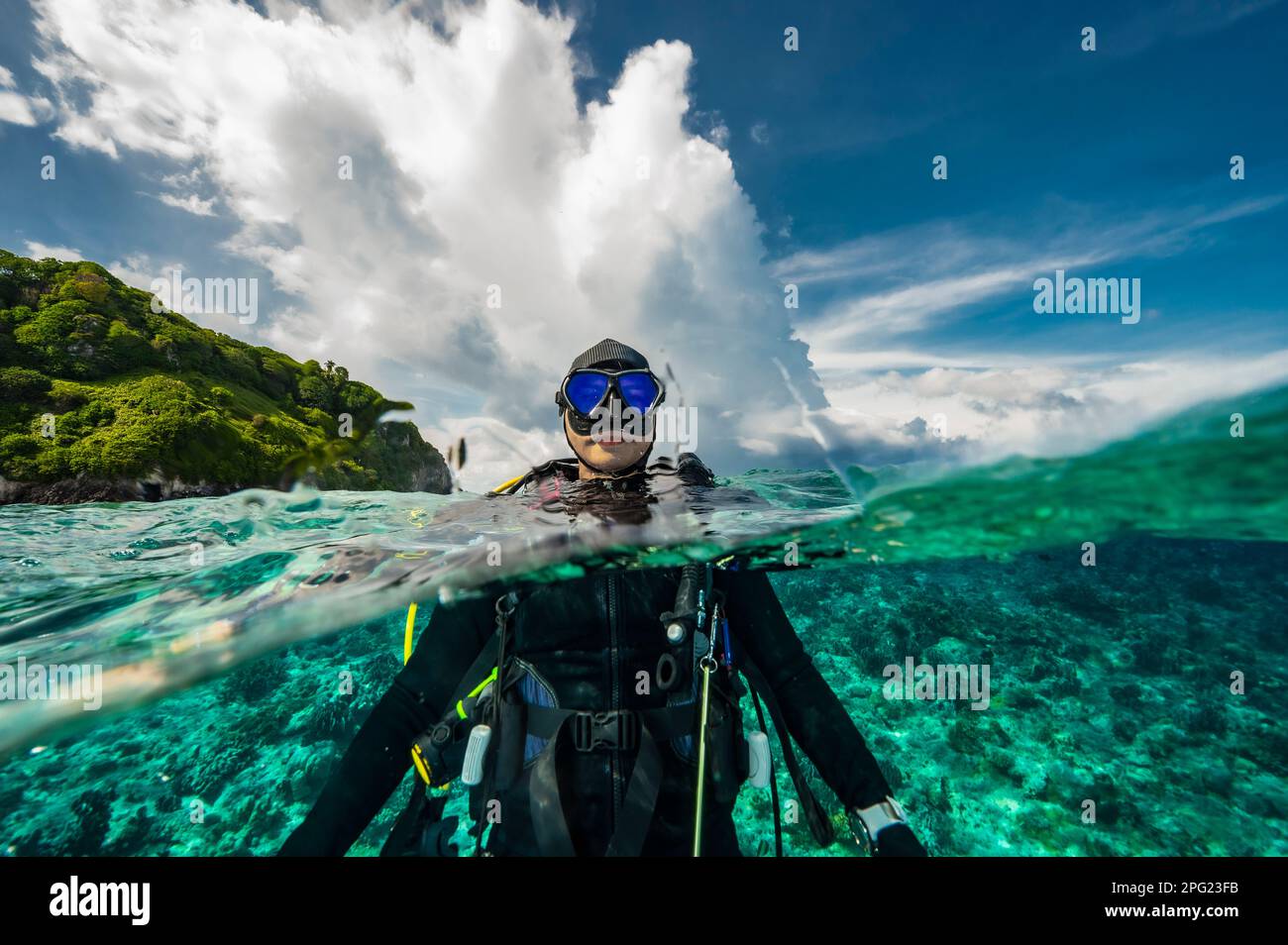Tuffatore che si affaccia sulle acque tropicali del mare di banda Foto Stock