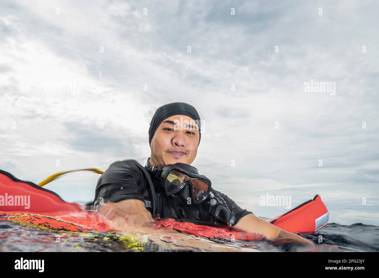 Tuffatore che si affaccia sulle acque tropicali del mare di banda Foto Stock