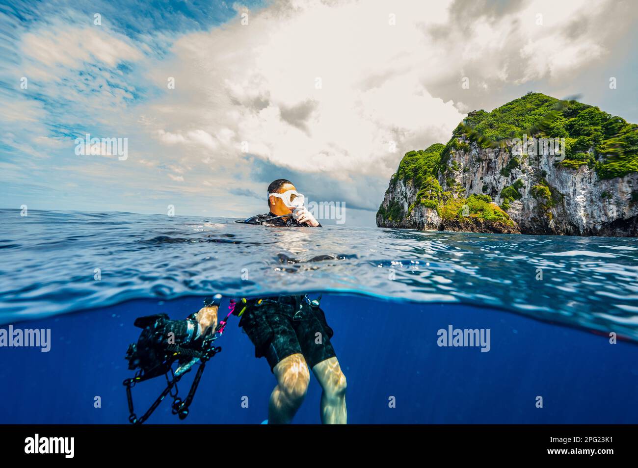 Tuffatore che si affaccia sulle acque tropicali del mare di banda Foto Stock