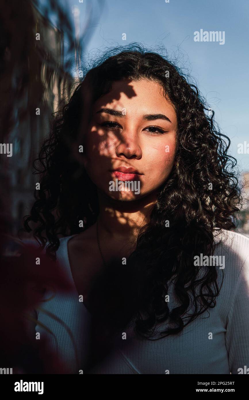 foto d'archivio di un ritratto di ragazza latina con luce solare e ombre Foto Stock