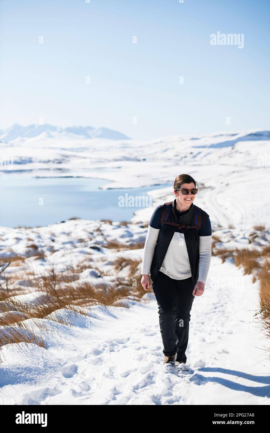 Millenial Woman escursioni attraverso la neve sull'Isola di Skye Highlands scozzesi Foto Stock