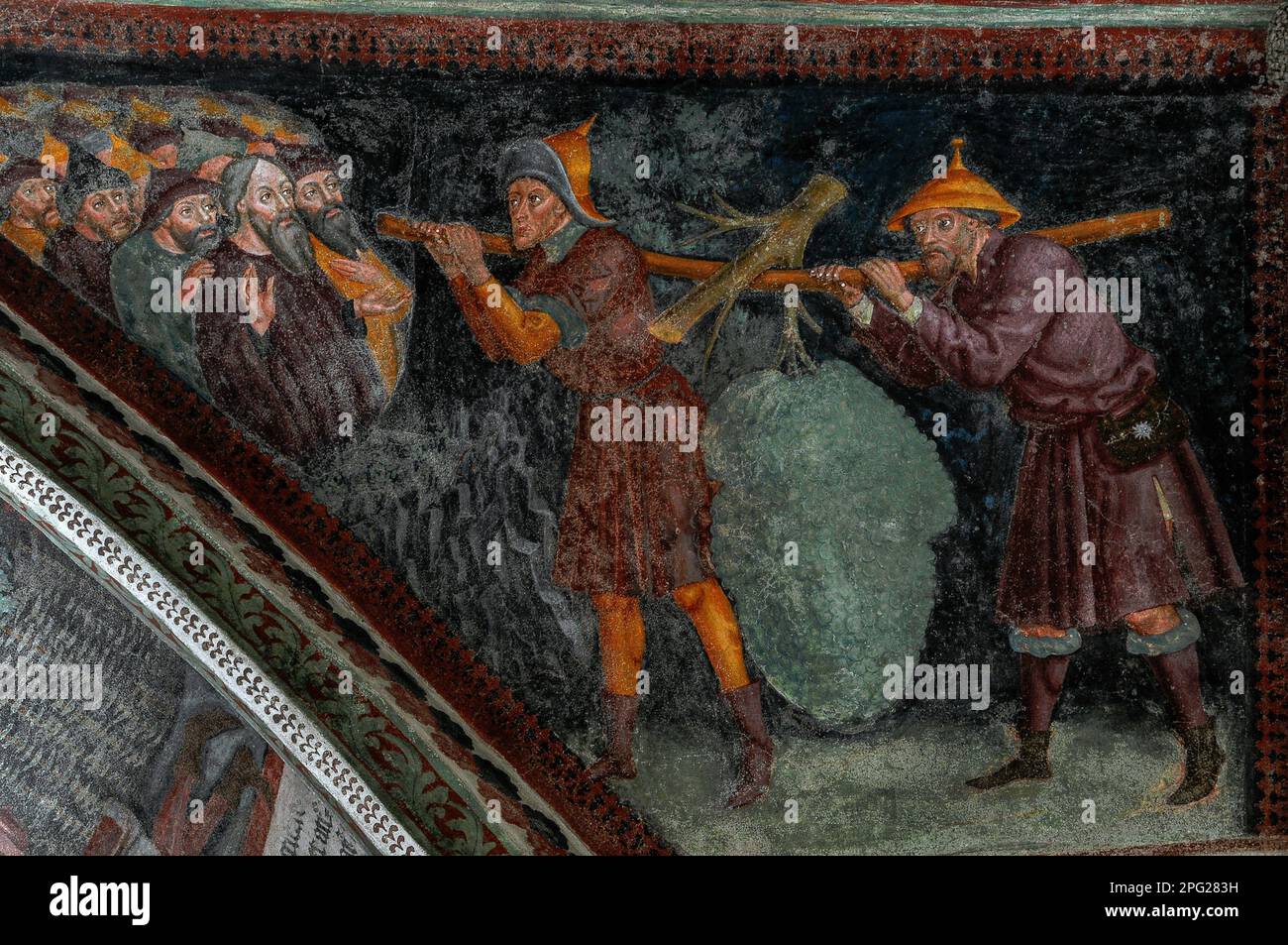 Giosuè e Caleb, inviati da Mosè per esplorare la Terra promessa, tornano dalla Terra di Canaan agli Israeliti in attesa che trasportano un enorme ammasso di uva. Affresco tardogotico nel chiostro medievale accanto al Duomo di Bressanone (Cattedrale di Santa Maria Assunta) a Bressanone-Bressanone, alto Adige, Italia. Foto Stock