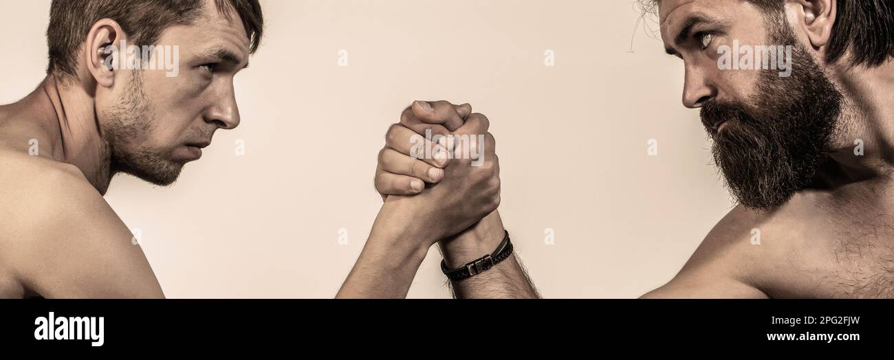 Armi che lottano mano sottile, grande braccio forte in studio. Due mani di uomo hanno stretto il braccio wrestling, forte e debole, corrispondenza disuguale Foto Stock