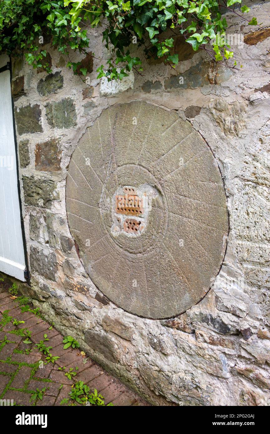 Pietra di mulino incorporato in muro a Hele Corn Mill, Ilfracombe, North Devon, Regno Unito Foto Stock