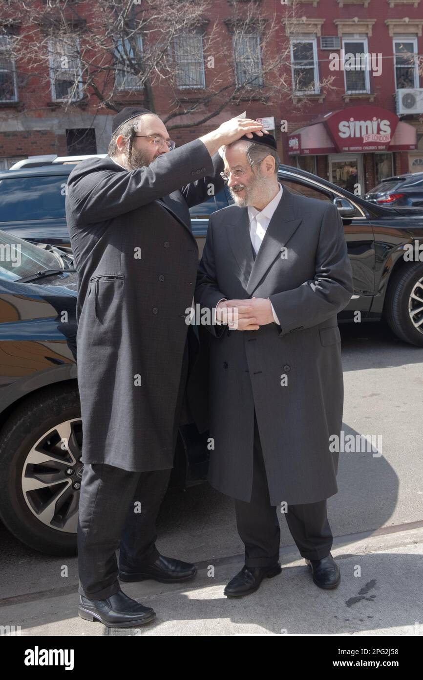 Un rabbino attivista della comunità che raccoglie denaro per nutrire i poveri benedice un grande donatore. A Brooklyn, New York. Foto Stock