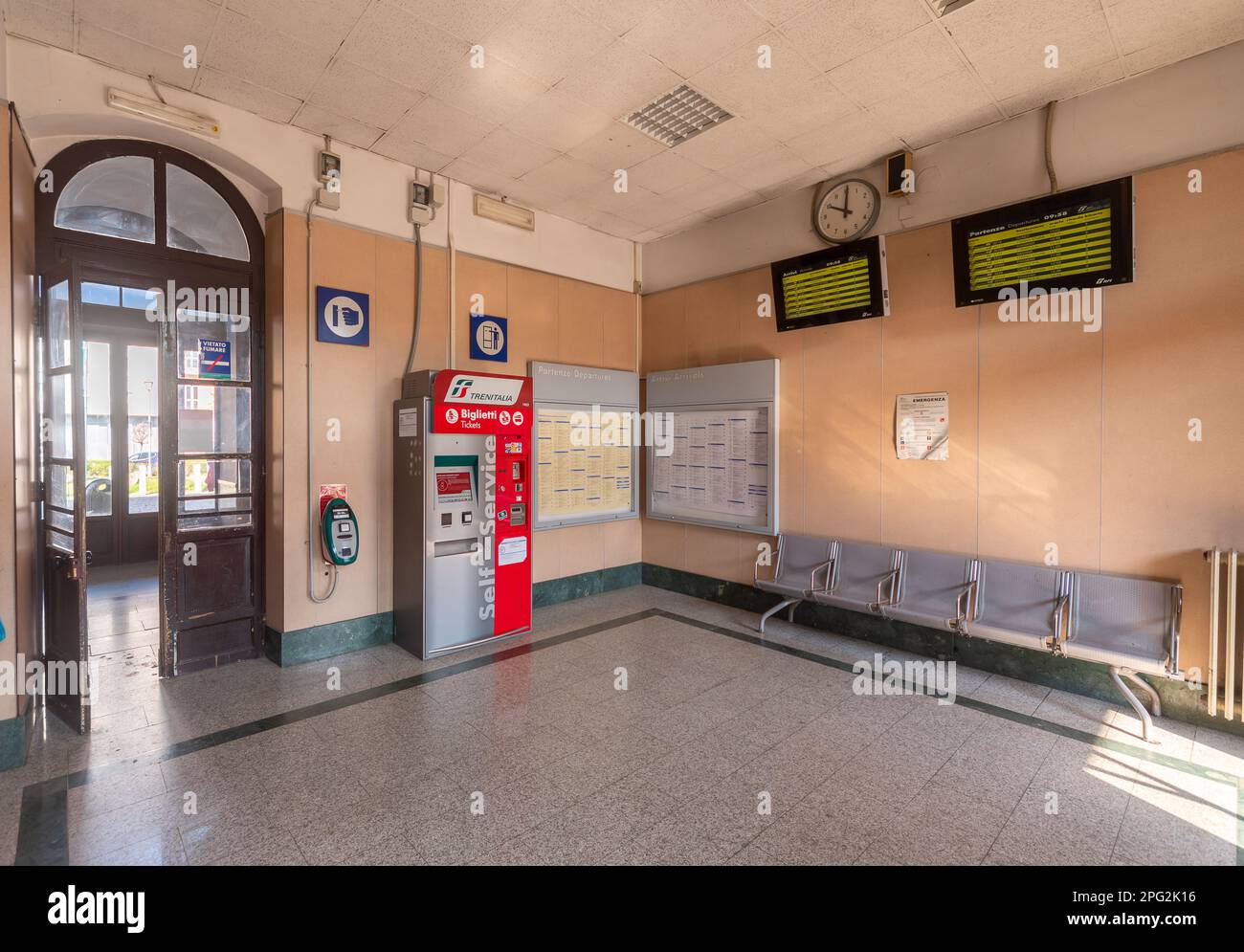 Savigliano, Cuneo, Italia - 20 marzo 2023: Sala d'attesa con distributore automatico di biglietti Trenitalia e orario del treno ha condotto lo slay in treno Foto Stock