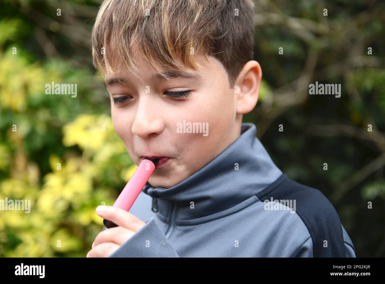 Schoolboy vaping illegale Foto Stock