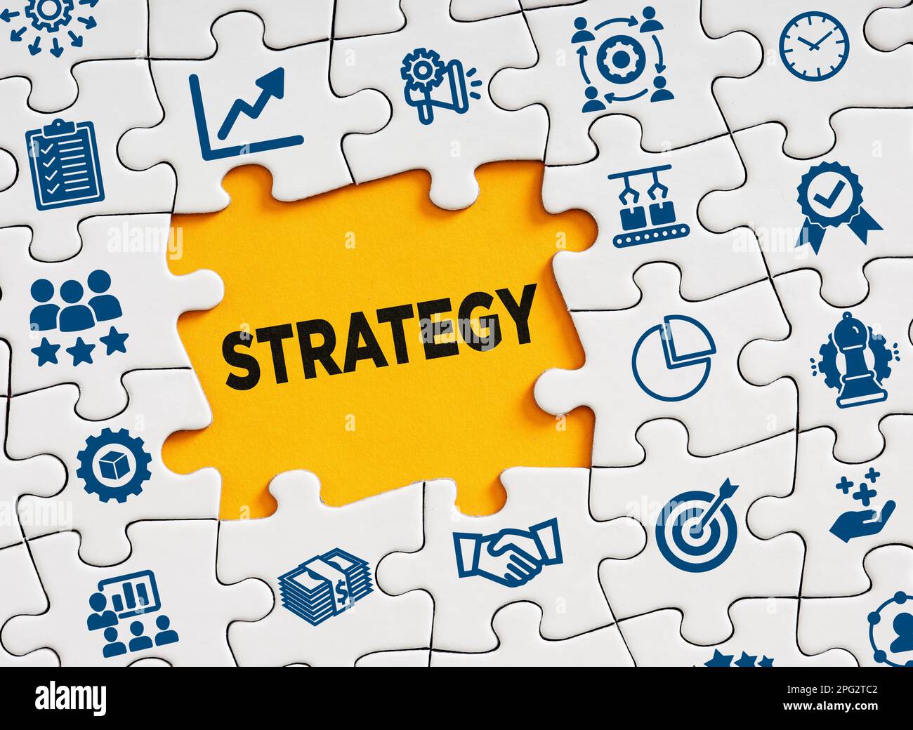 Concetto di strategia aziendale. La strategia di affari di parola i in un pezzo mancante del puzzle con i simboli di affari. Foto Stock