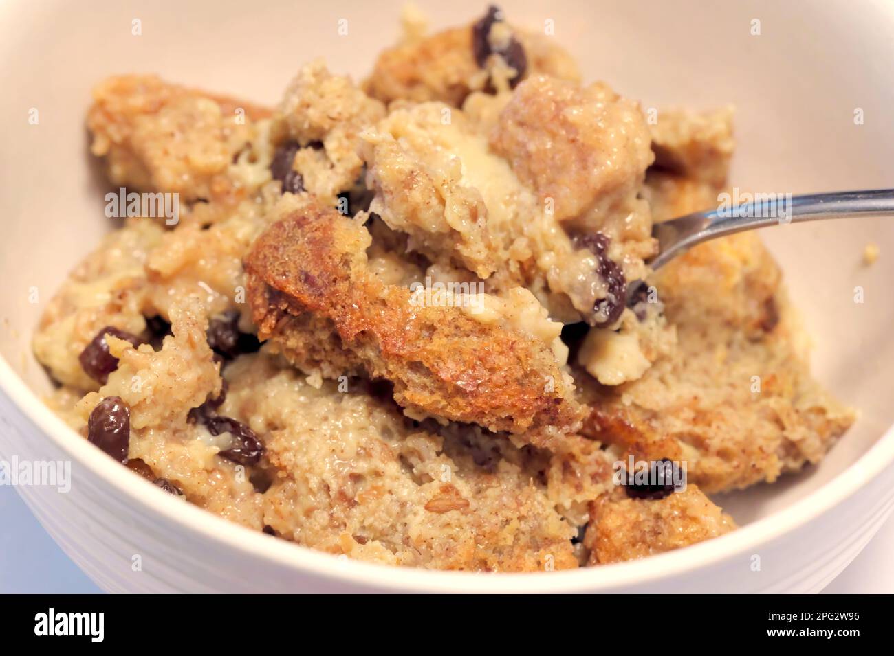 Pane fatto in casa Pudding con uvetta in una ciotola con cucchiaio. Foto Stock