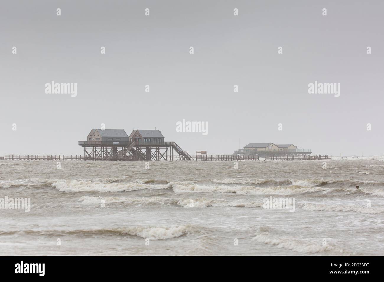 Case a palafitte sulla spiaggia di San Pietro-Ording, una popolare località balneare tedesca, durante un temporale. Schleswig-Holstein, Germania Foto Stock