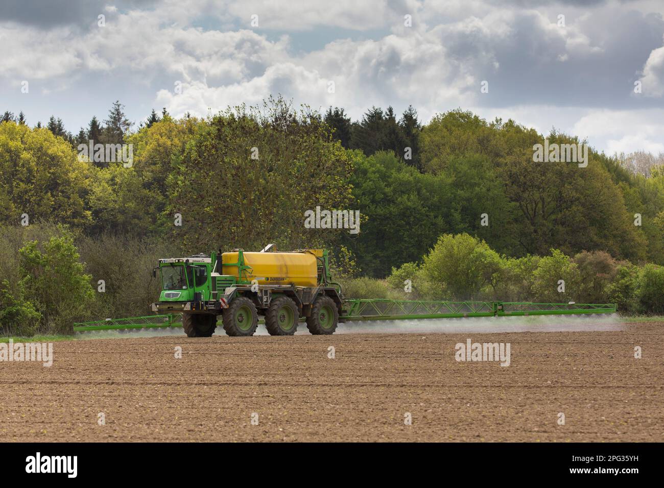 Coltivatore che spruzza un campo. Meclemburgo-Pomerania occidentale, Germania Foto Stock